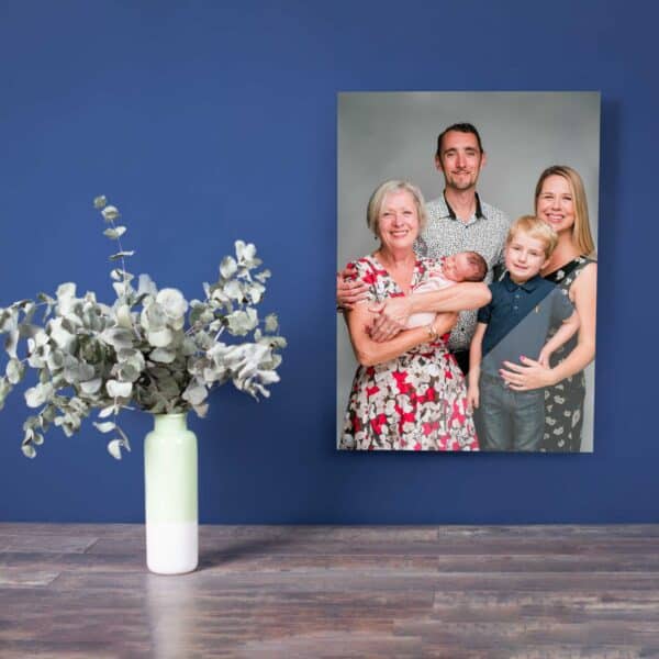 This image showcases a canvas family portrait, featuring a family of three smiling and looking at the camera in a beautifully lit outdoor setting. The canvas print is of high quality, with sharp details and vivid colors, and is displayed on a wall, adding a personal touch to the home decor.