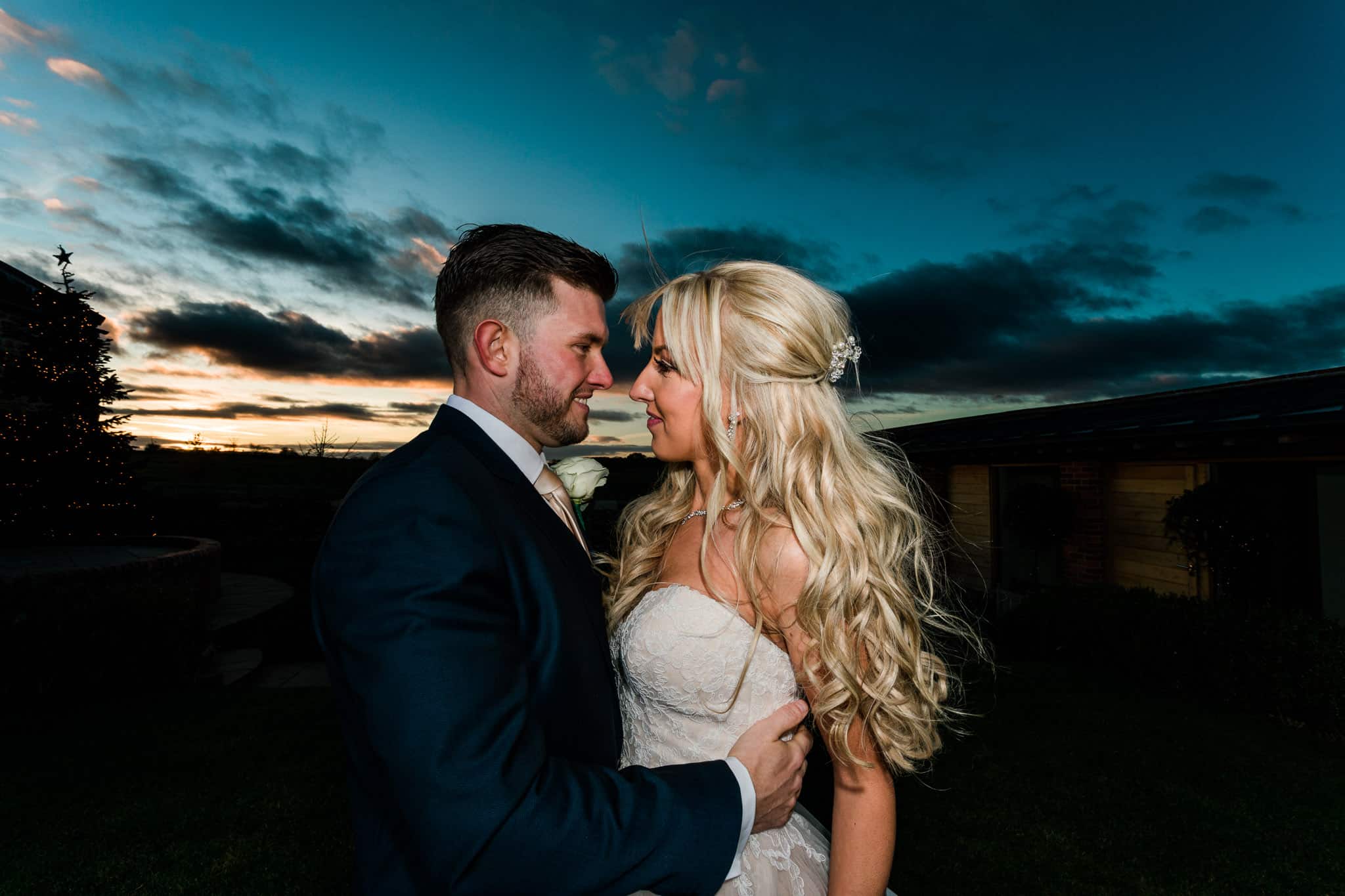 Bride and groom kissing during sunset on their wedding day at Dodford Manor.
