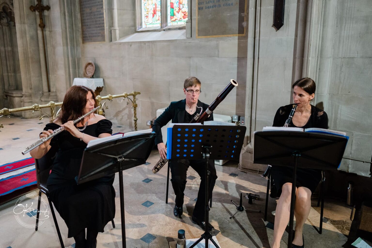 Ettington Park Hotel Wedding Photography Three musicians playing flute, bassoon, and clarinet in an indoor venue.