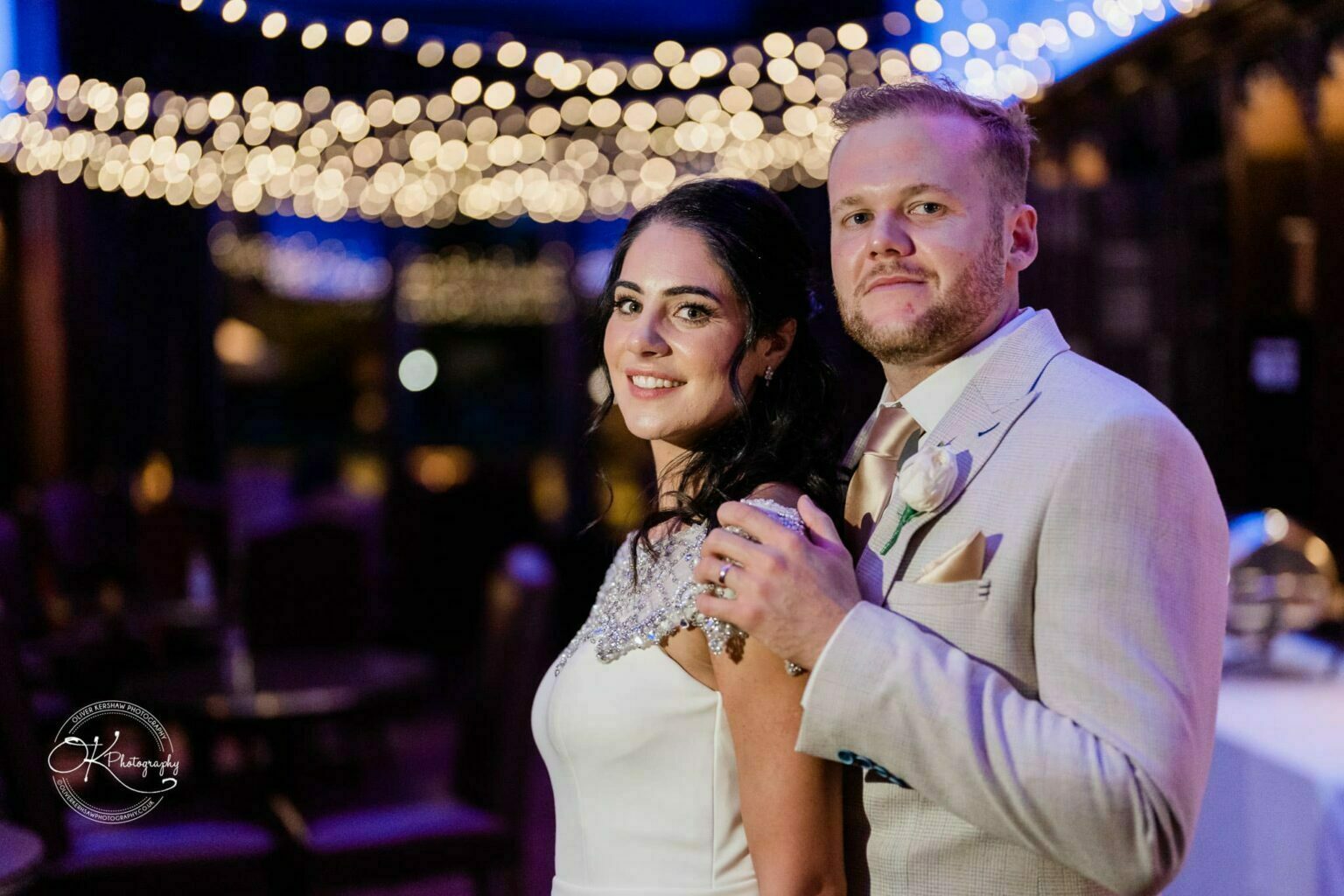 Ettington Park Hotel Wedding Photography A bride and groom posing together indoors with bokeh lights in the background.