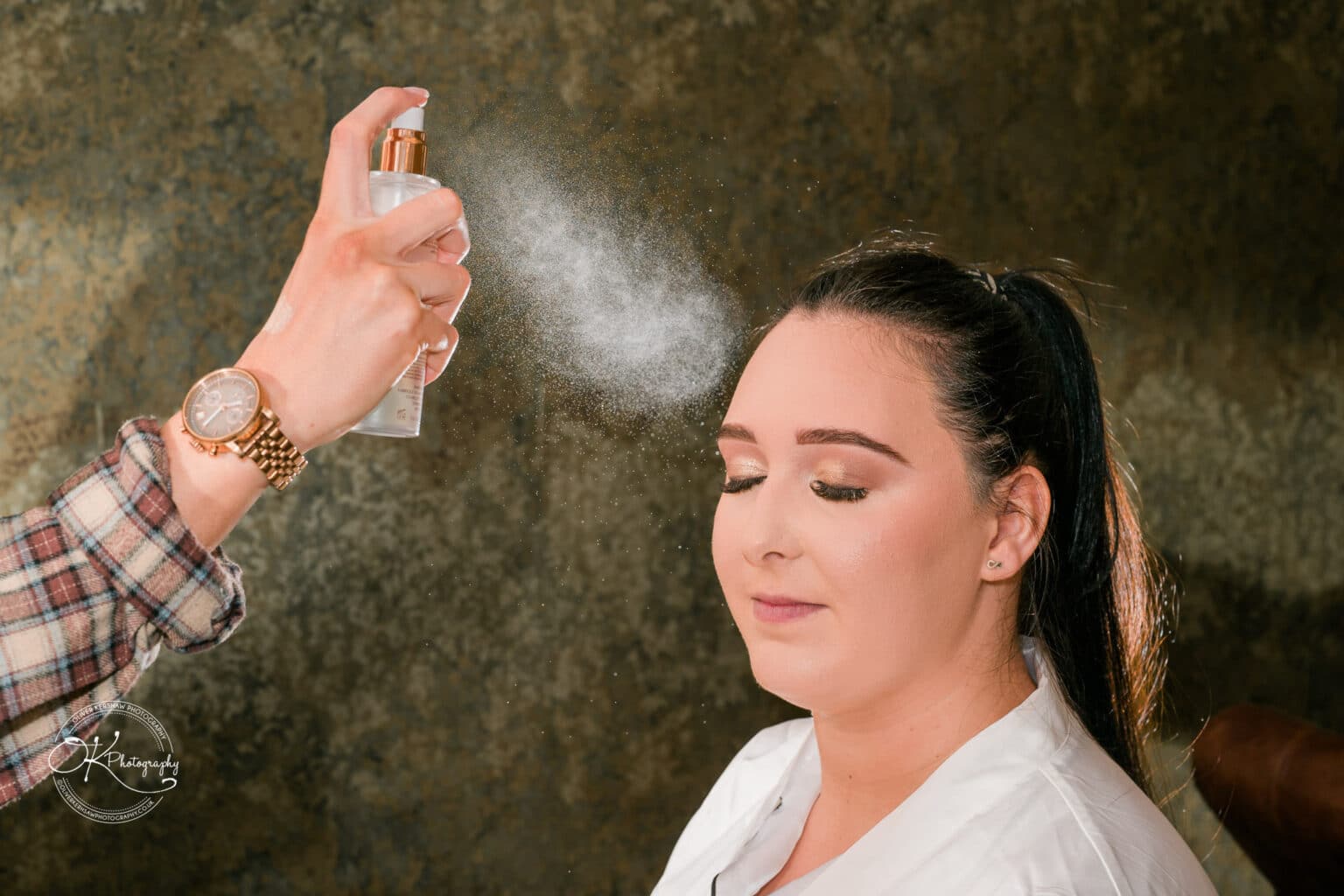 Mythe Barn Wedding photography A bride having her makeup set with a spray.