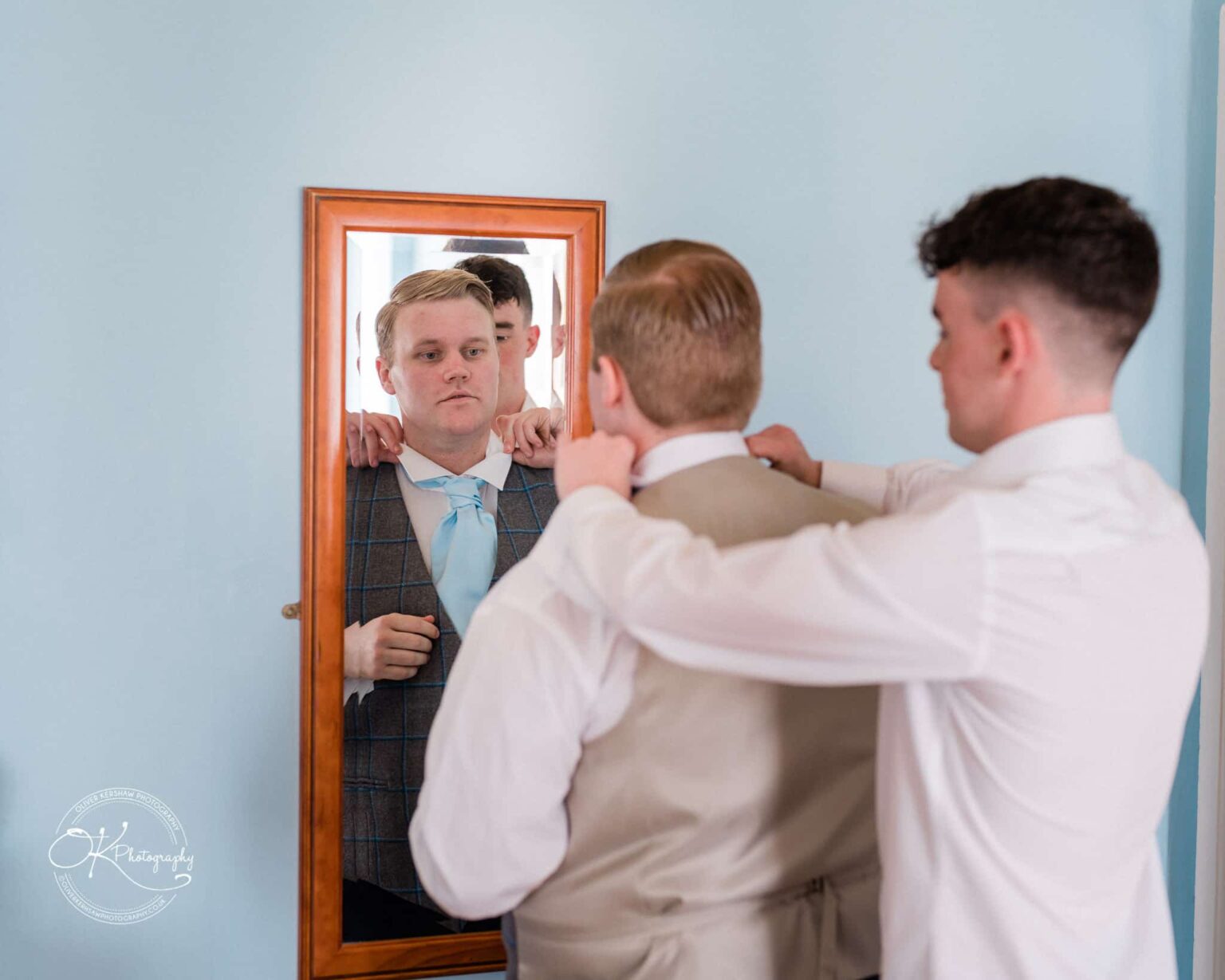 Prestwold Hall Wedding Photography Two men adjusting their ties in front of a mirror.