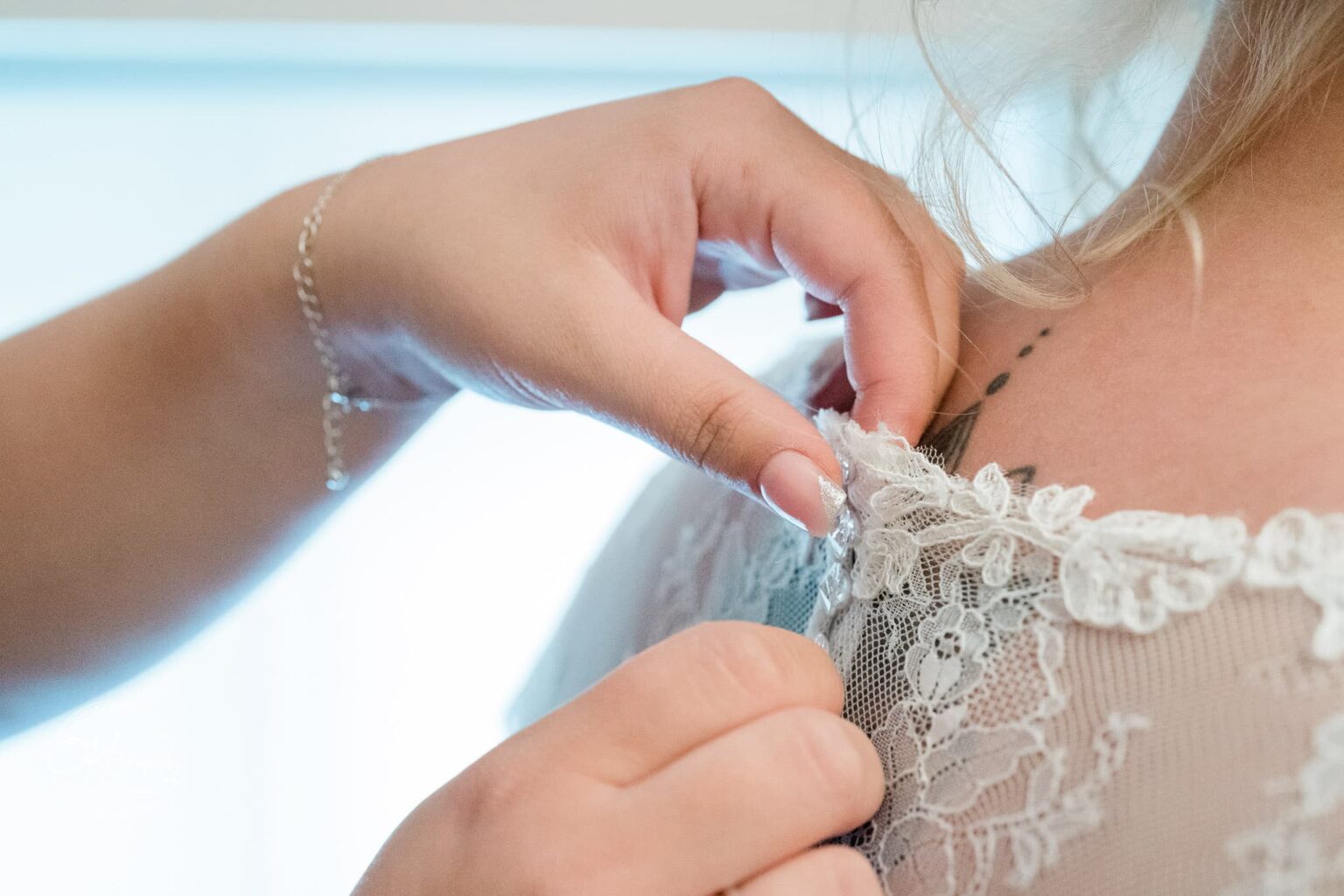 Santos Higham Farm Wedding Photography Hand adjusting lace on a wedding dress near the shoulder.