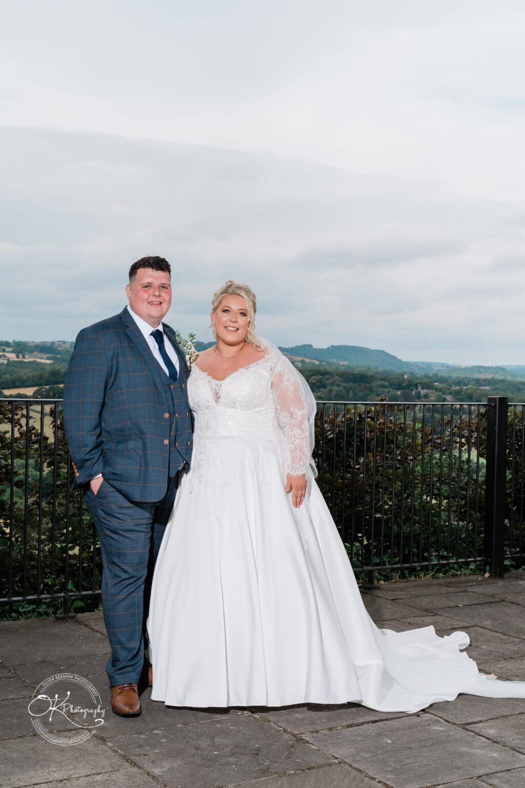 Santos Higham Farm Wedding Photography Bride and groom standing outdoors with a scenic landscape in the background.