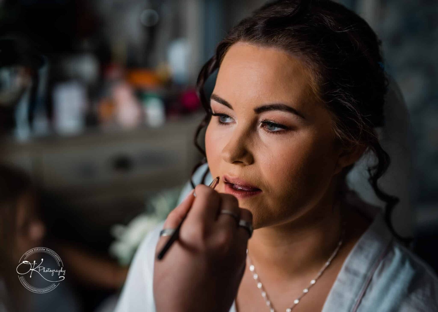 Shearsby Bath Wedding Photography A woman having lipstick applied with a makeup brush.