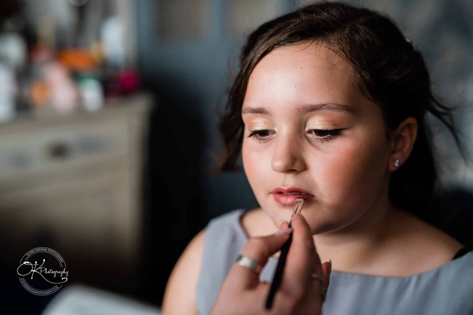 Shearsby Bath Wedding Photography A young person having their lipstick applied with a brush.