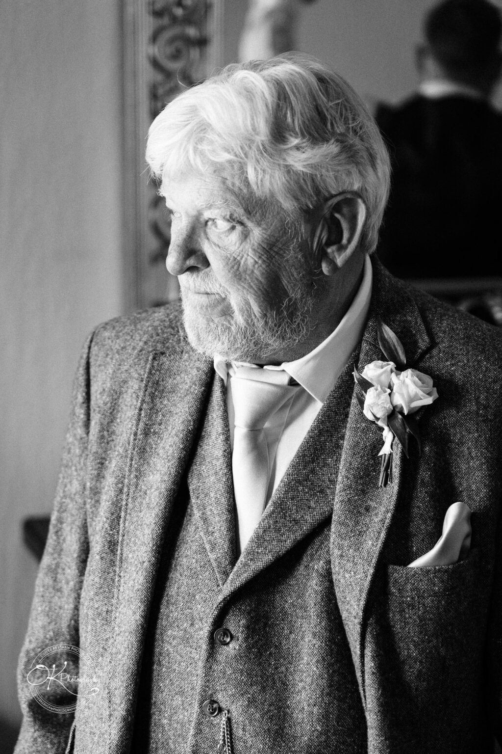 Black and white photograph of an elderly man with white hair and beard wearing a suit and boutonnière.