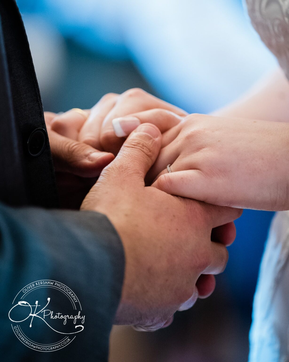 Close-up of a couple holding hands during a wedding ceremony.