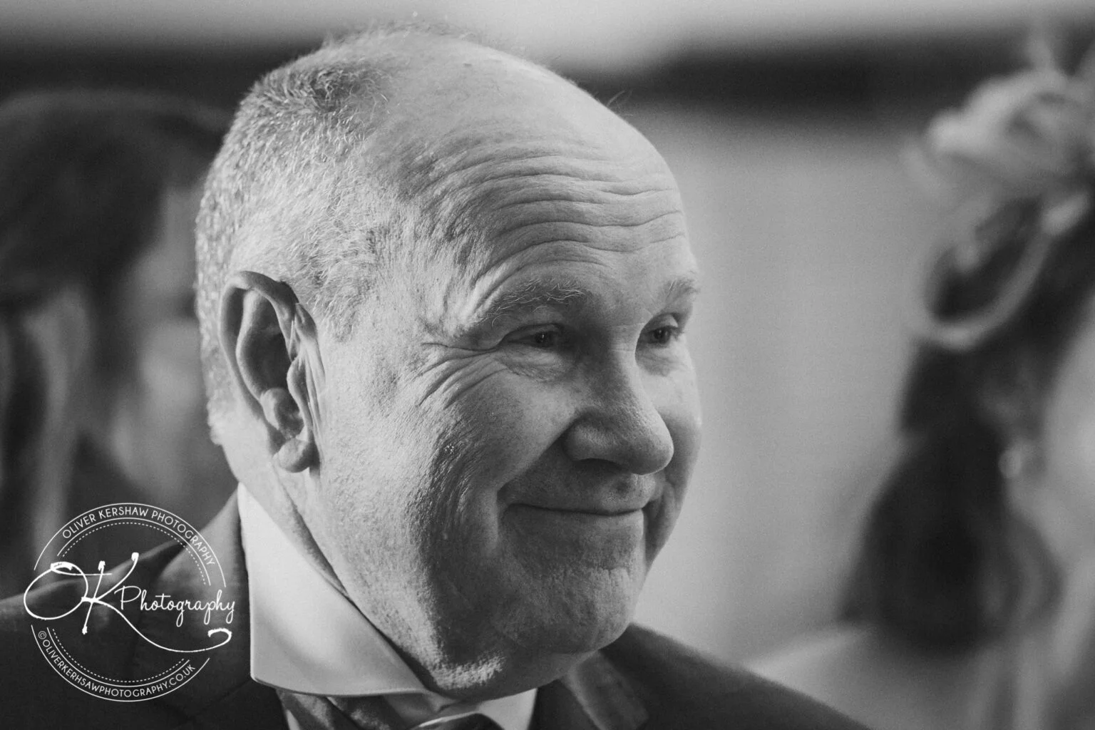 An elderly man smiling at an event.