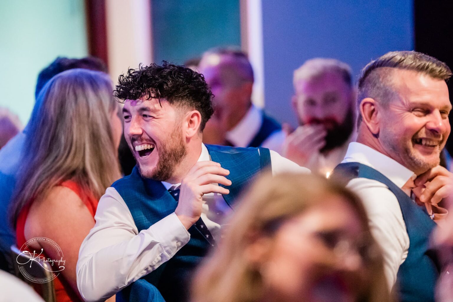 A group of people in formal attire laughing and socialising at an event.