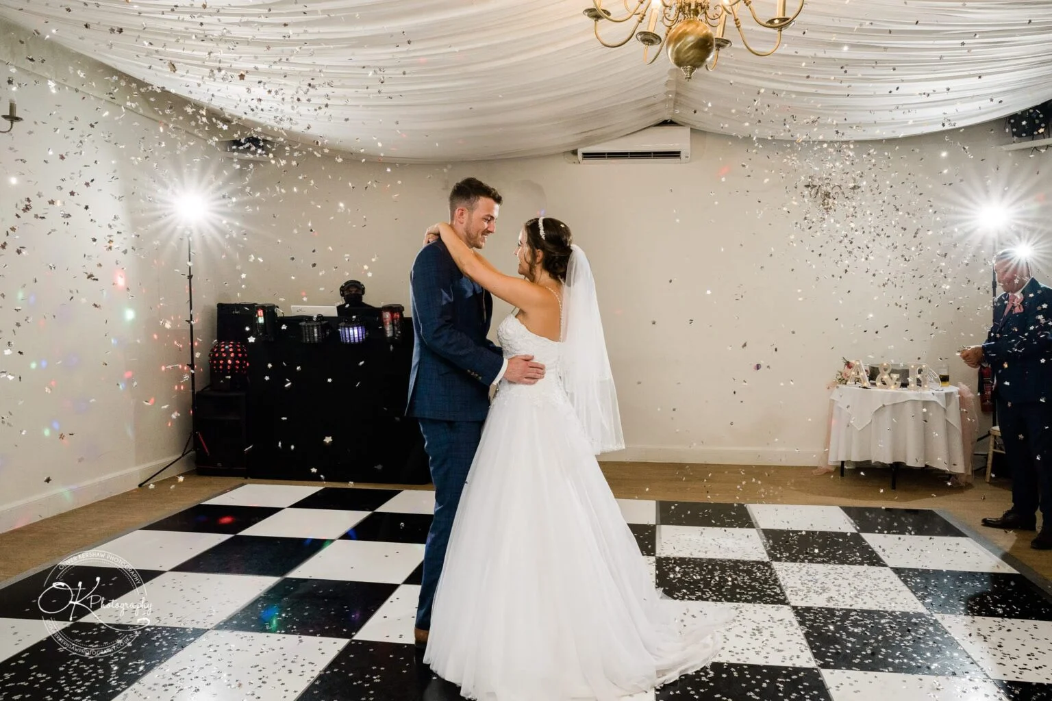 Warwick House Wedding Photography Bride and groom dancing under confetti on a chequered dance floor at a wedding reception.