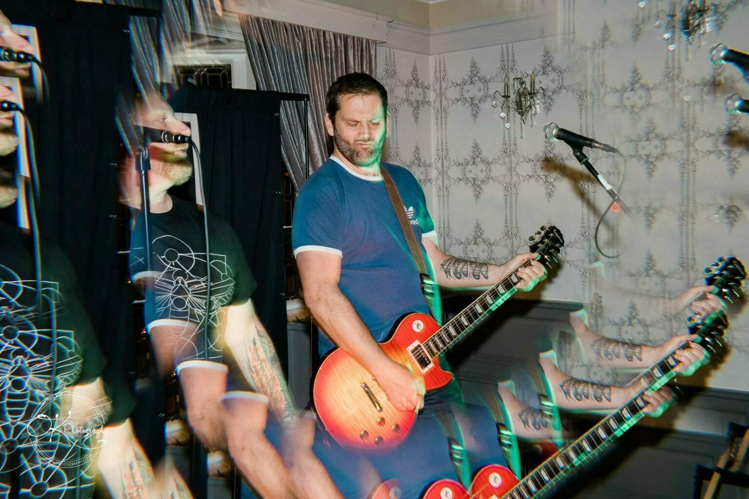 Wedding photography The Embankment Musician playing a guitar on stage with a psychedelic visual effect.