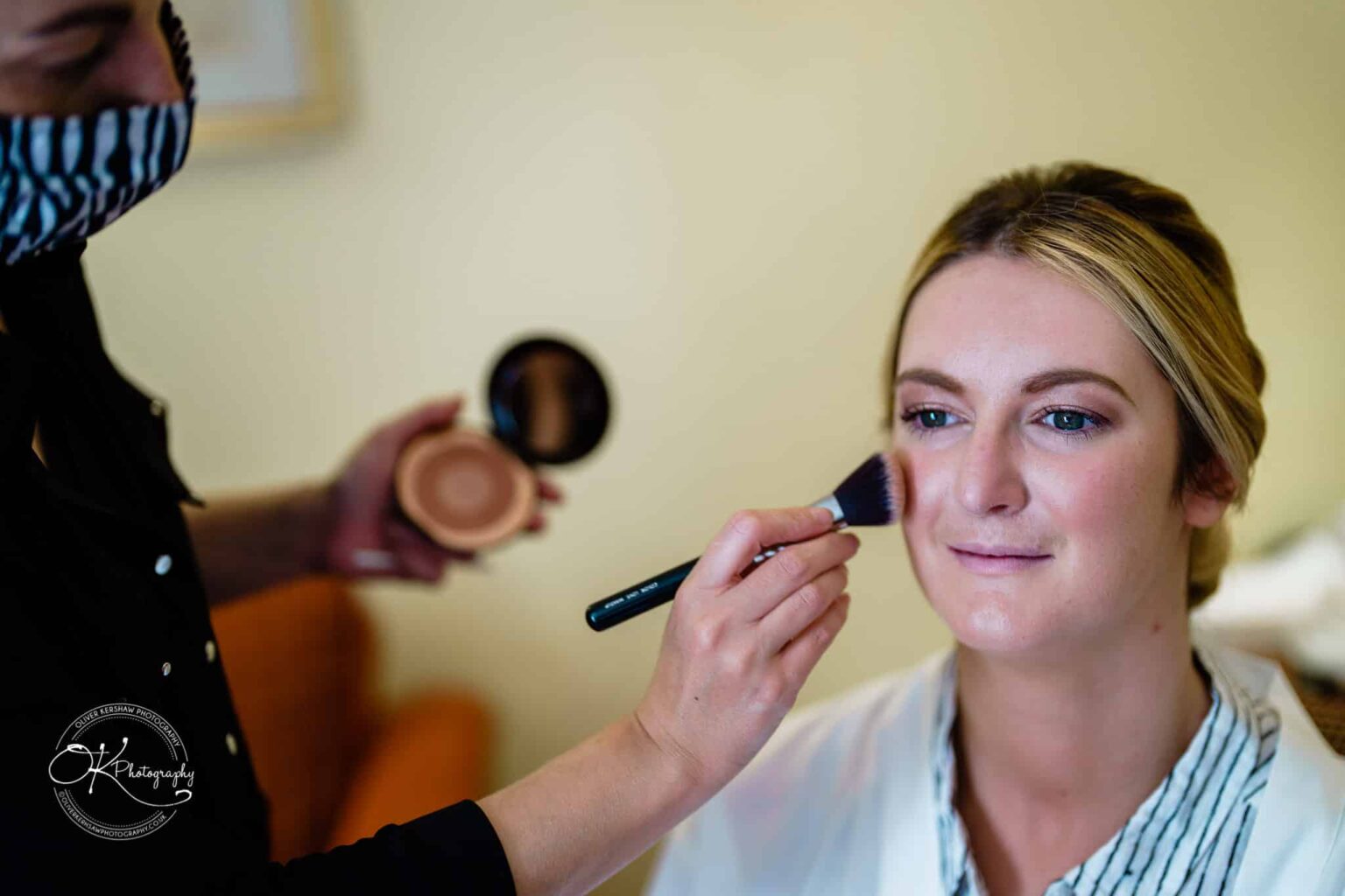 Yew Lodge Hotel Wedding Photography Bride having makeup applied with a brush.