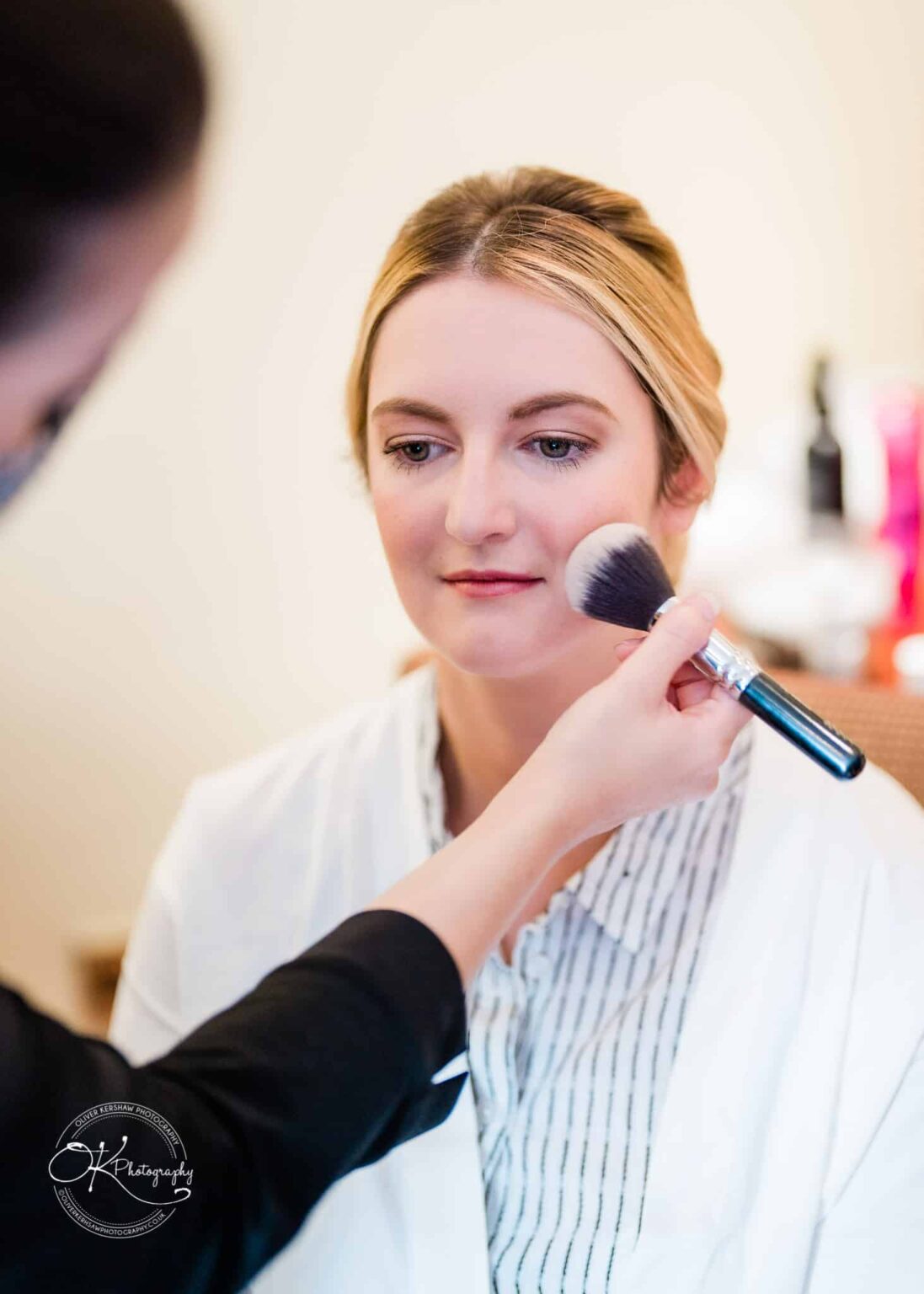 Yew Lodge Hotel Wedding Photography A woman getting her makeup done by a makeup artist.