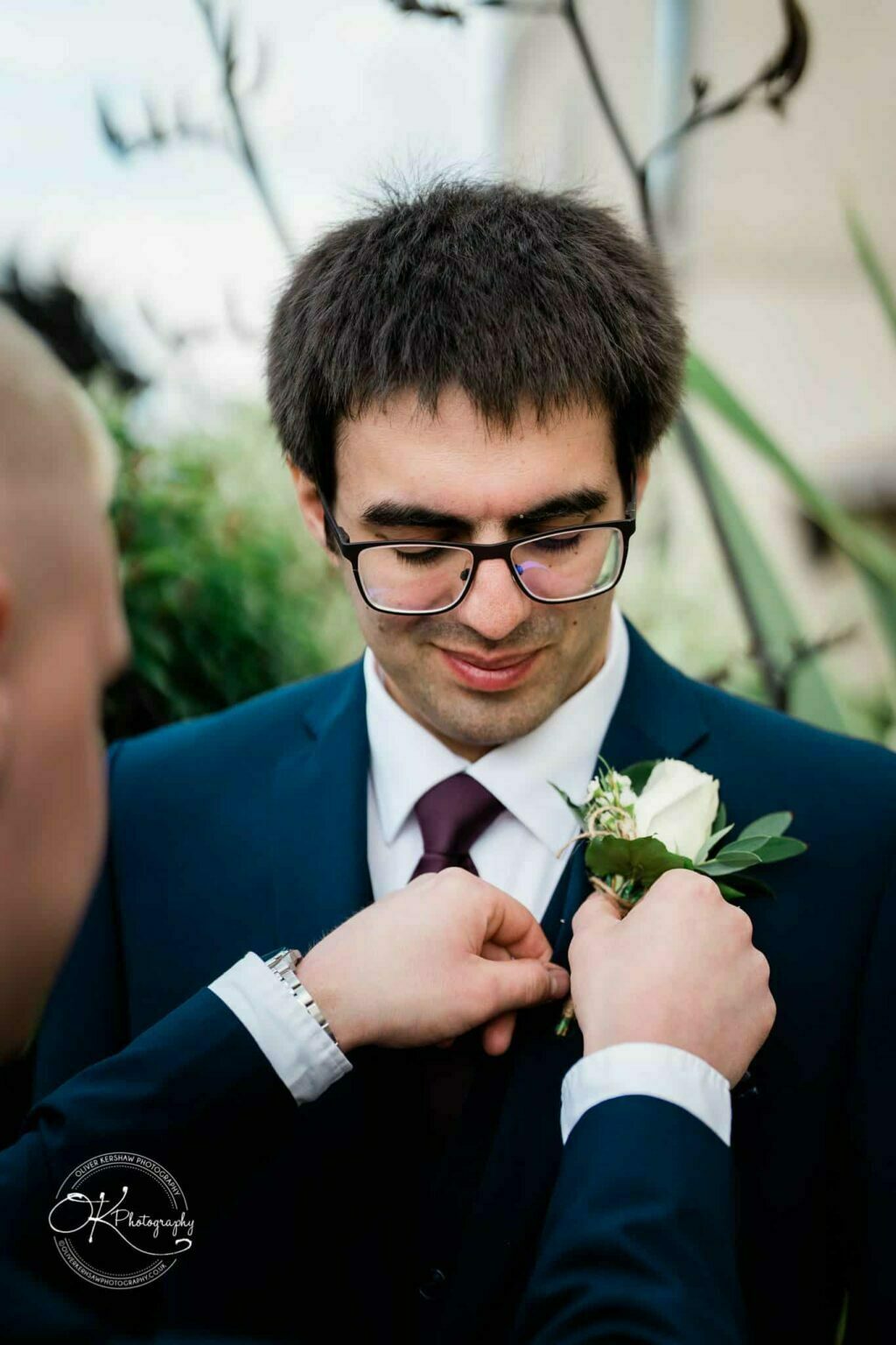 Yew Lodge Hotel Wedding Photography A man in a suit having a boutonniere pinned to his lapel.