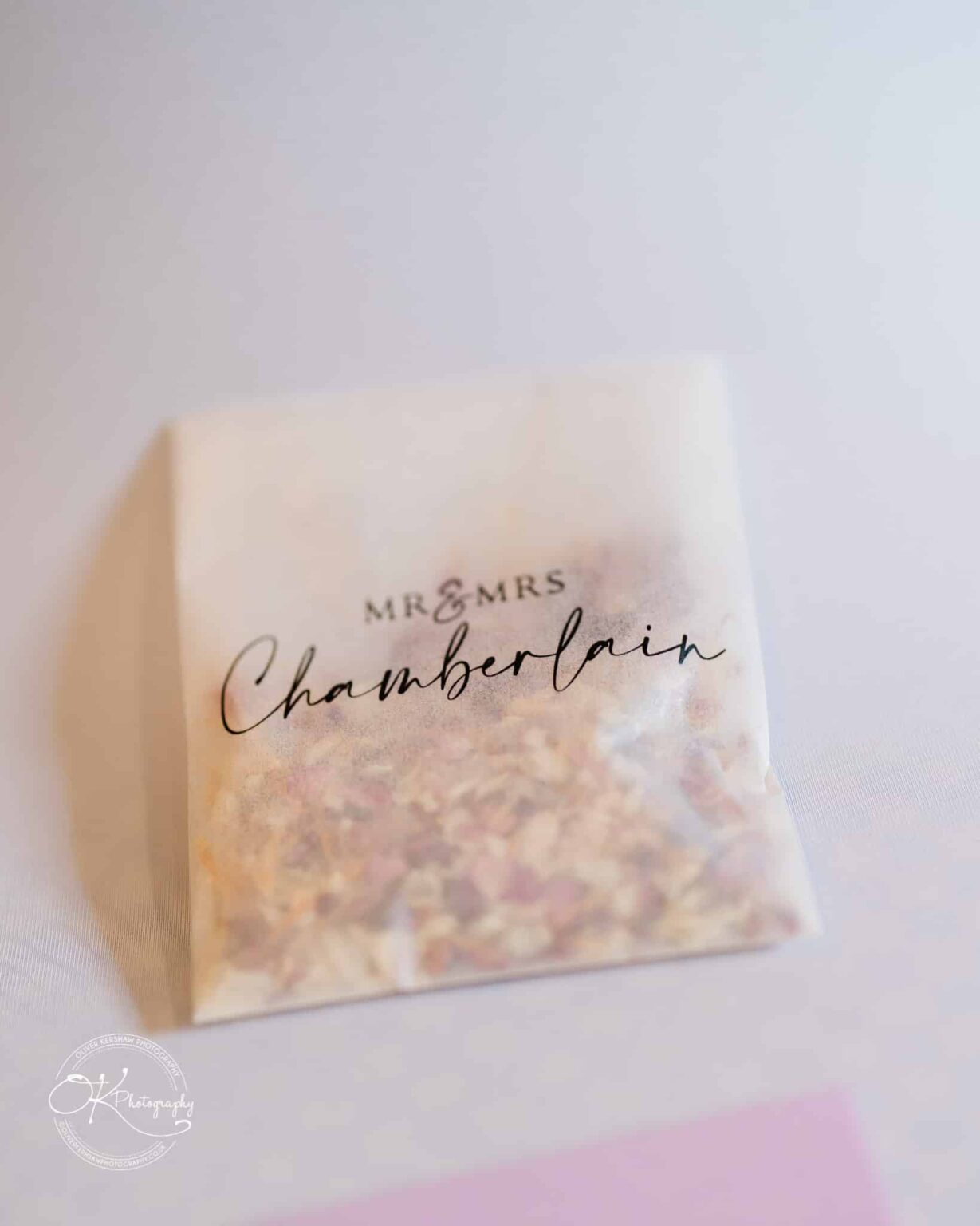 Yew Lodge Hotel Wedding Photography Envelope with dried flower petals labeled "Mr & Mrs Chamberlain" on a white surface.