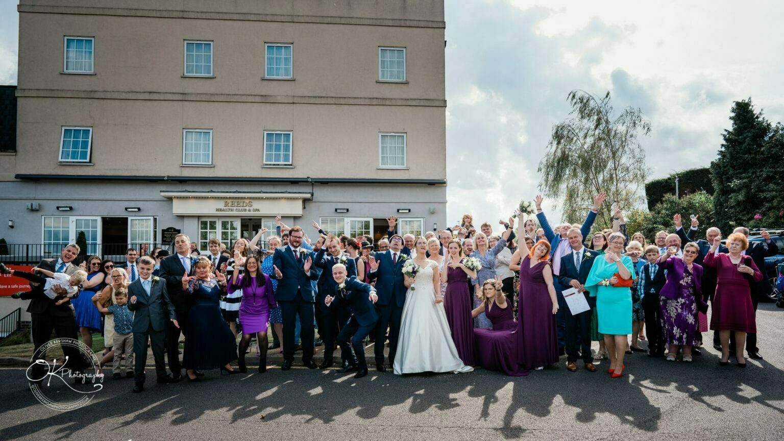 Yew Lodge Hotel Wedding Photography A large wedding group posing cheerfully outside the Yew Lodge Hotel.