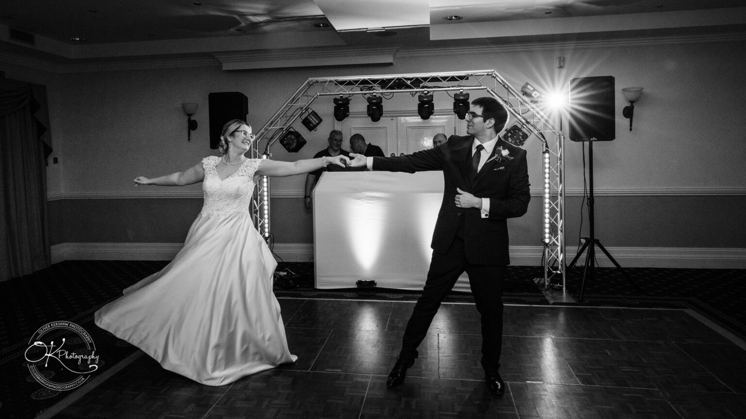 Yew Lodge Hotel Wedding Photography A newlywed couple dancing in an elegantly lit ballroom at Yew Lodge Hotel.
