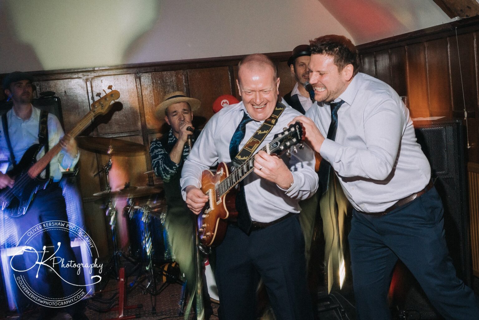Wedding Photography George Hotel Stamford People enjoying live band performance with guitarist, singer, bassist, and drummer at George Hotel Stamford.