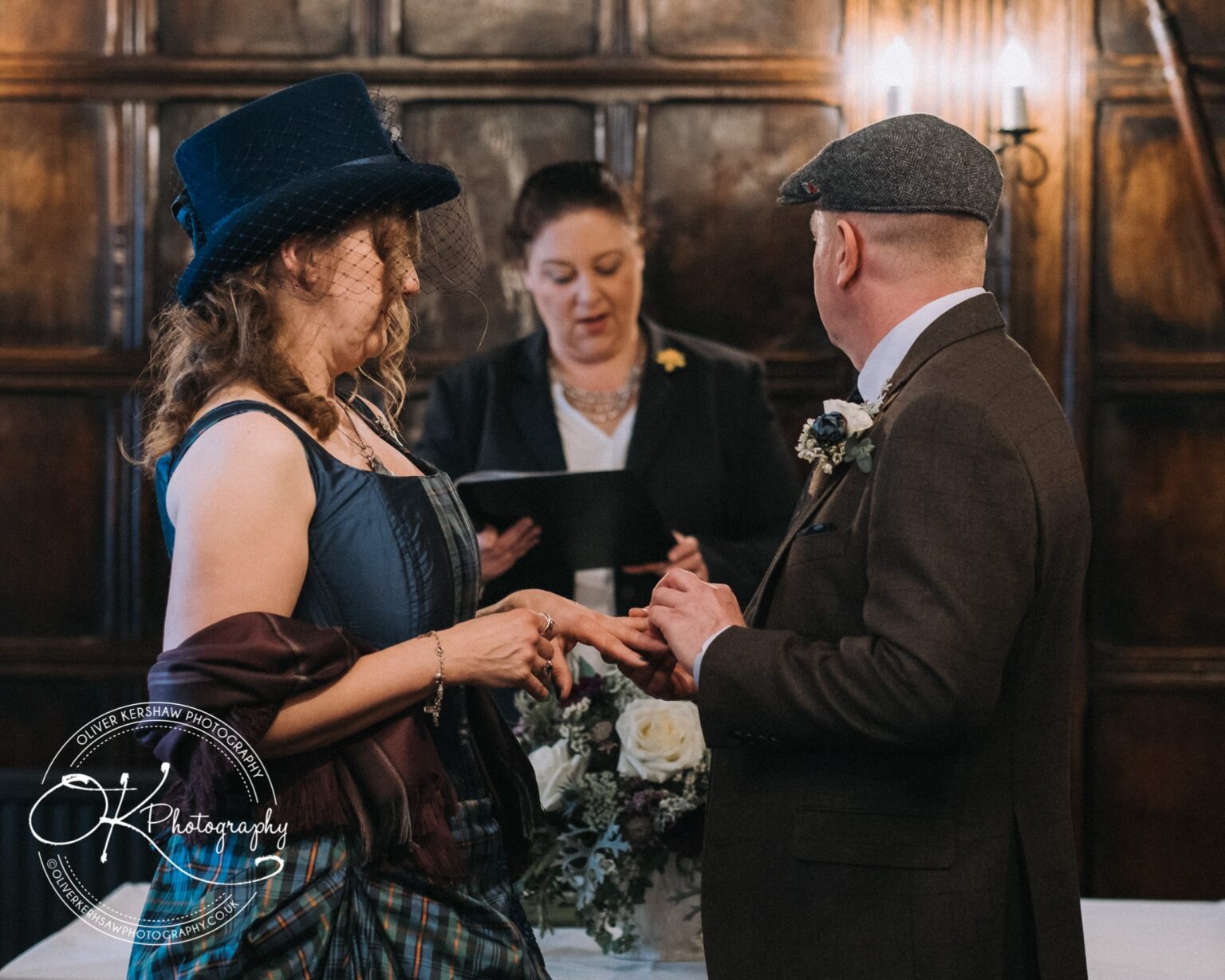 Wedding Photography George Hotel Stamford A couple exchanging rings in a wedding ceremony at the George Hotel in Stamford, with an officiant reading from a book in the background.