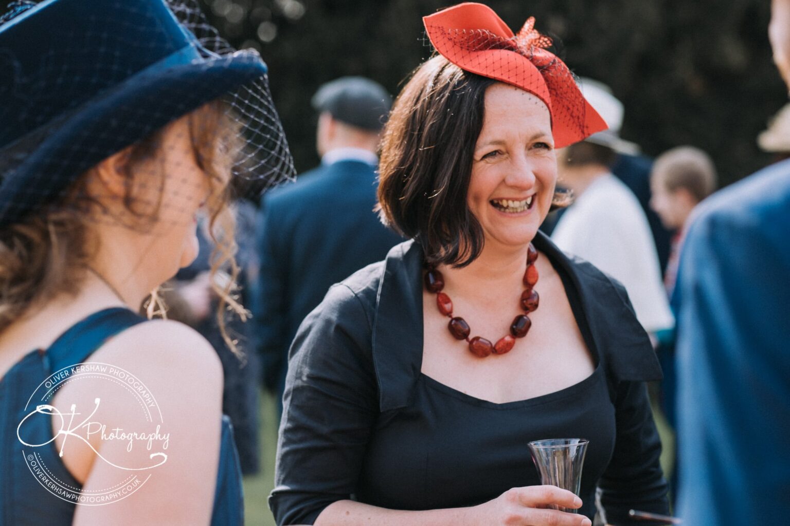 Wedding Photography George Hotel Stamford Two women in formal attire laughing and chatting at an outdoor event.