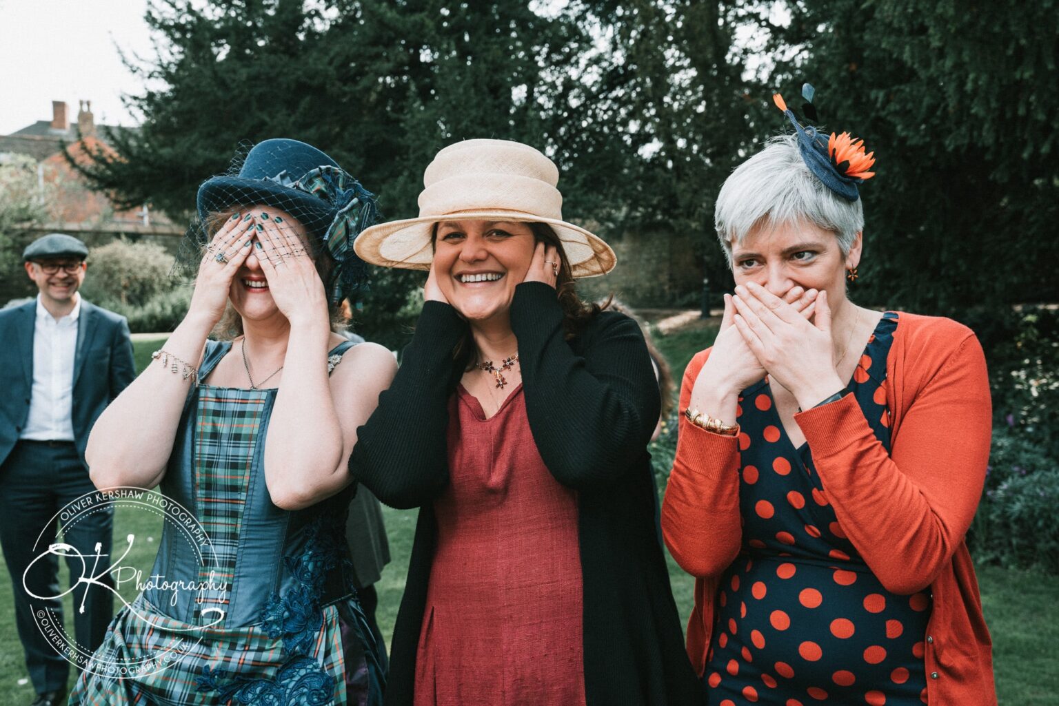 Wedding Photography George Hotel Stamford Three women posing playfully as "see no evil, hear no evil, speak no evil" in a garden, with a man in the background.