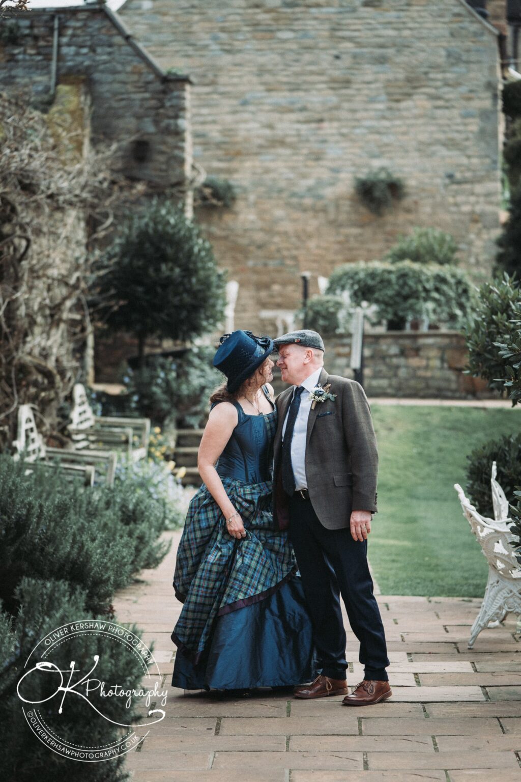 Wedding Photography George Hotel Stamford A couple dressed in formal attire sharing an intimate moment in the garden of the George Hotel in Stamford.