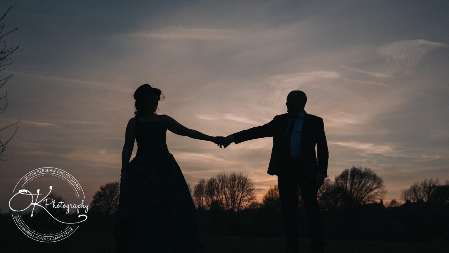 Wedding Photography George Hotel Stamford Silhouette of a couple holding hands against a sunset sky.