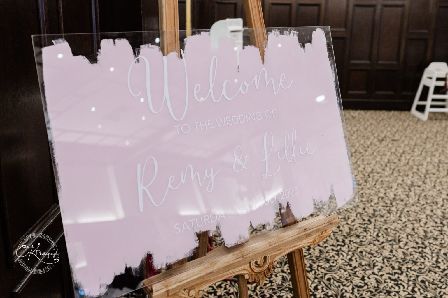 Wedding welcome sign on a wooden easel reading "Welcome to the wedding of Remy & Lillie, Saturday 29th July 2023" in Bosworth Hall Hotel.