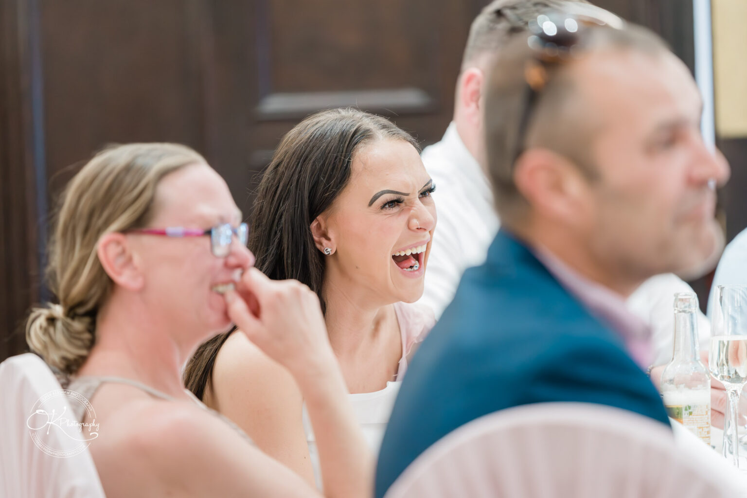 Guests laughing and enjoying themselves at an event, seated indoors at Bosworth Hall Hotel.
