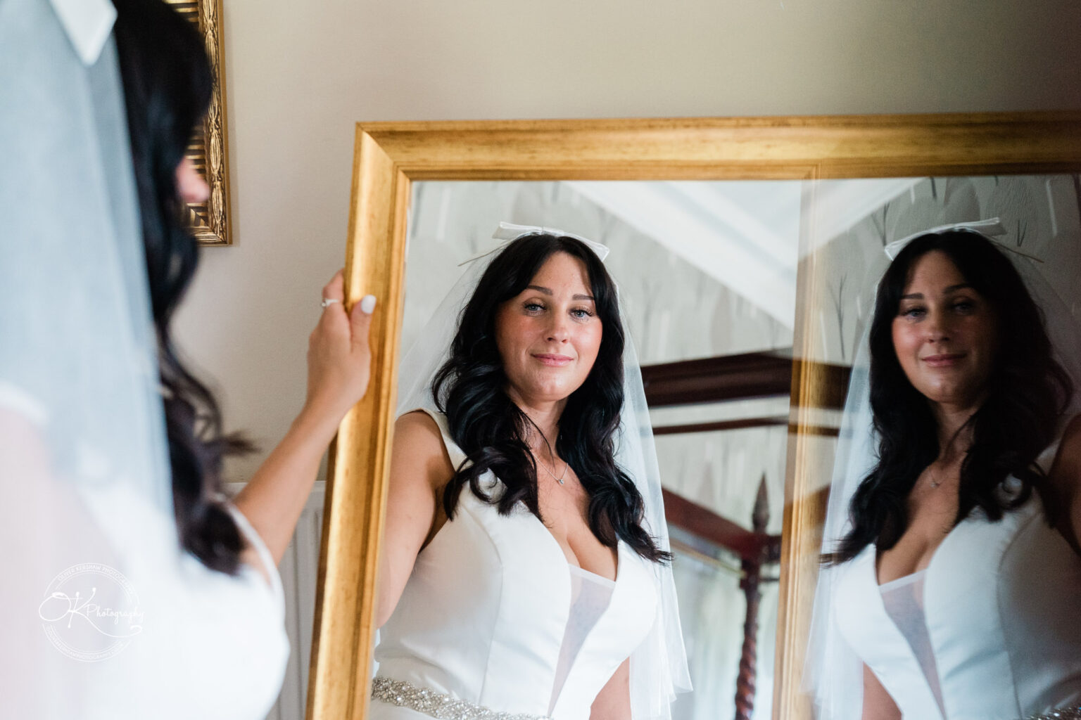 Rothley Court Hotel wedding photography Bride in a white dress and veil looking at her reflection in a mirror.