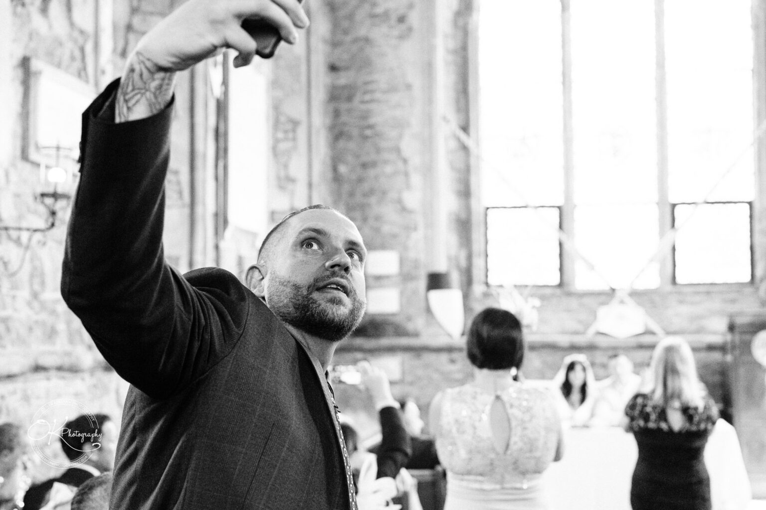 Rothley Court Hotel wedding photography Man taking a selfie in a brightly lit room with high ceilings and a large window in the background.