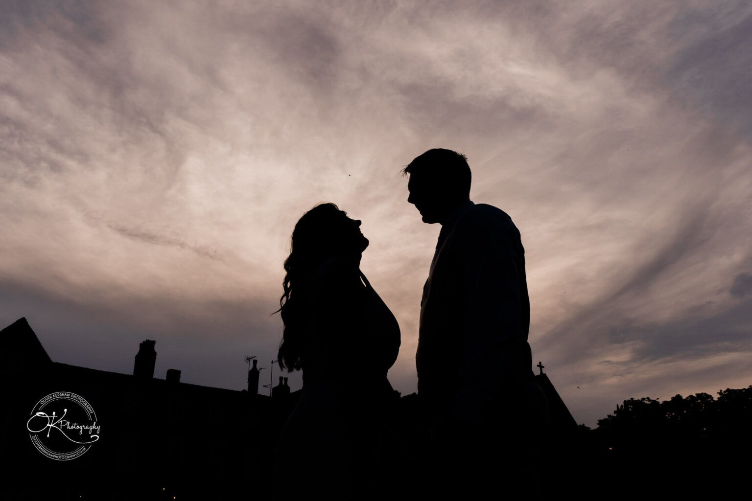 Rothley Court Hotel wedding photography Silhouette of a couple facing each other with a cloudy sky background.