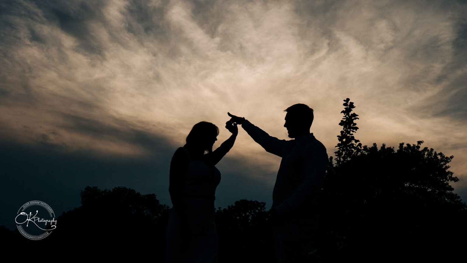 Rothley Court Hotel wedding photography Silhouette of a couple dancing against a dramatic, cloudy sky backdrop.