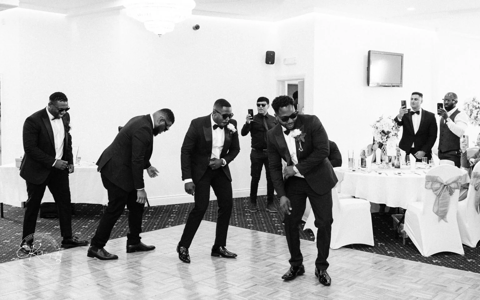 Men in suits dancing at a wedding reception.