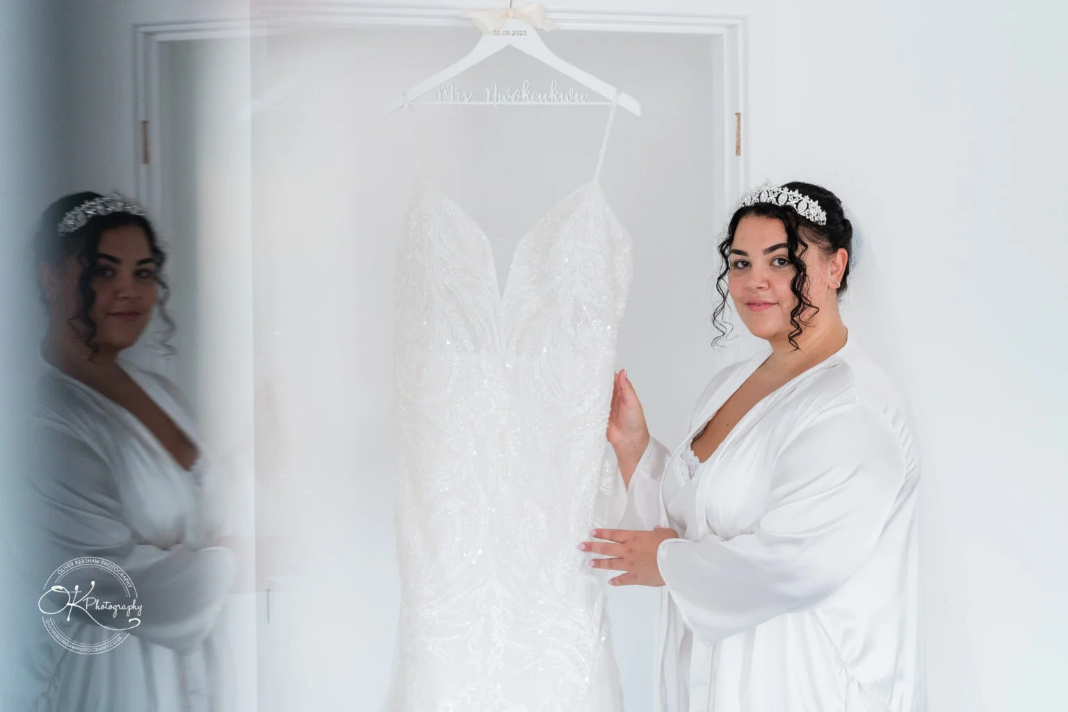Bride holding a white wedding dress on a personalised hanger.