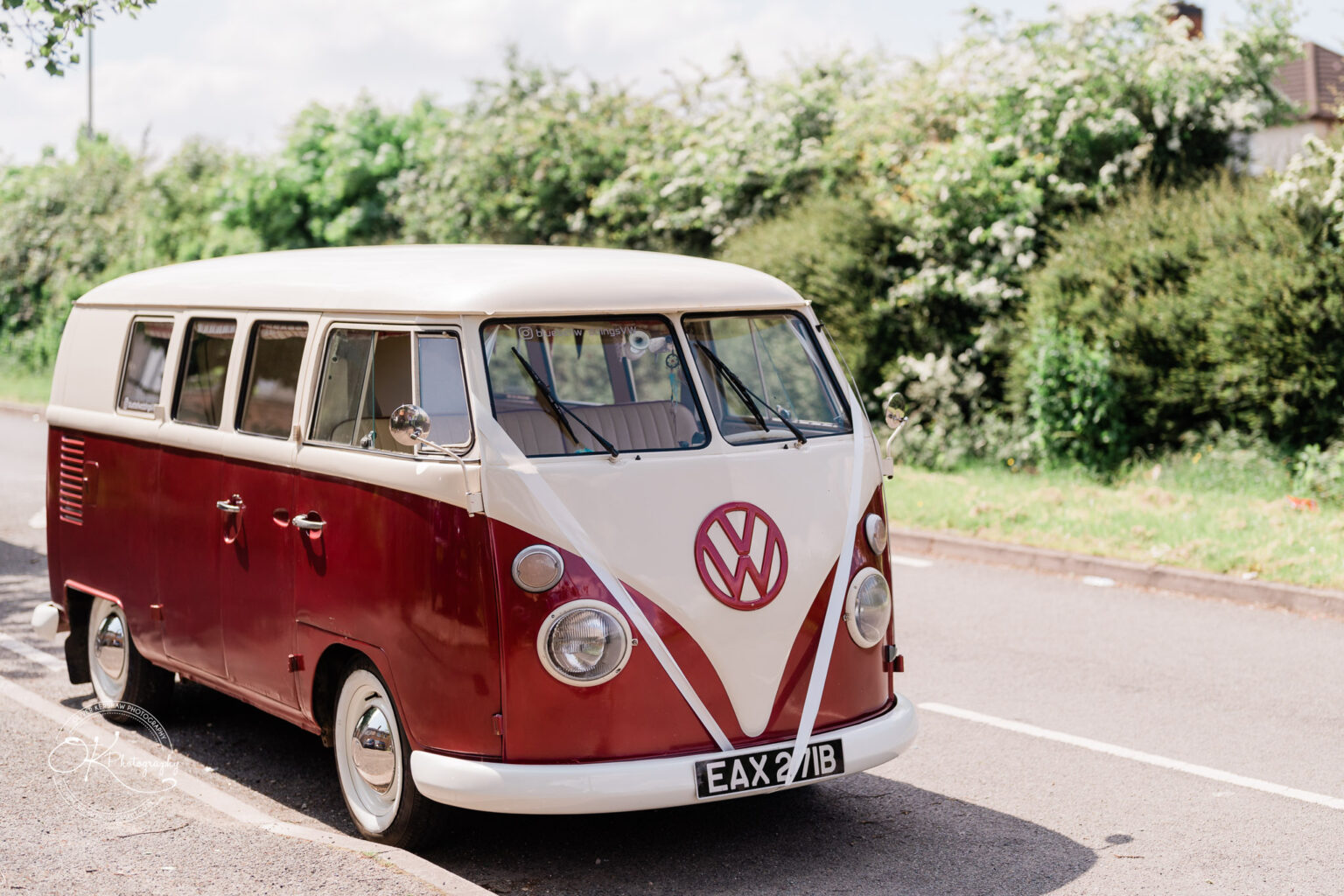 Vintage red and white Volkswagen camper van parked on a street.