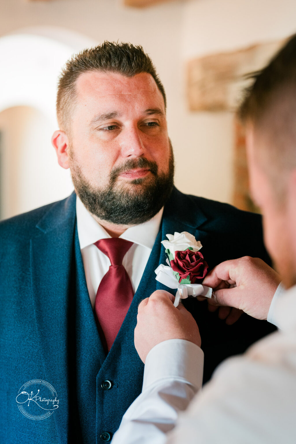 The cottage hotel - Wedding Photography Man in a suit having a boutonnière pinned on his lapel.