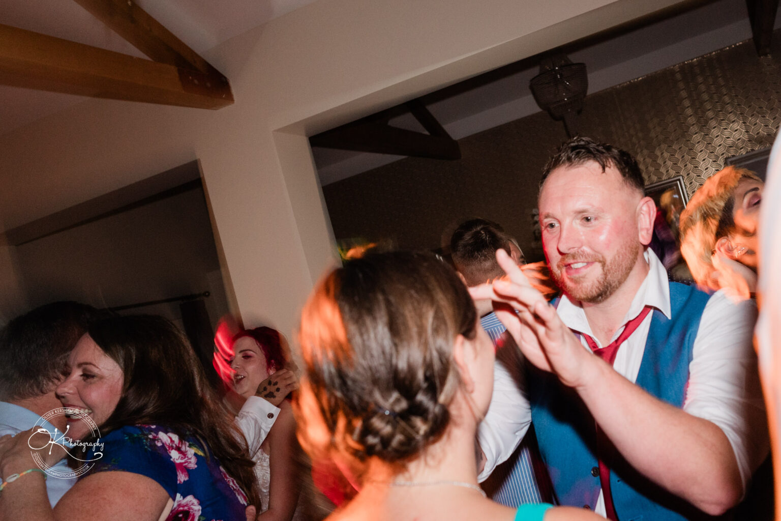The cottage hotel - Wedding Photography Guests dancing and enjoying a fun atmosphere at a party, with warm lighting and visible beams in the ceiling.
