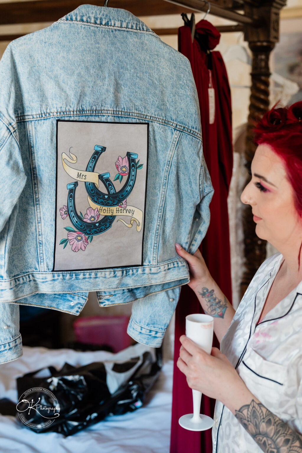 The cottage hotel - Wedding Photography Person holding a customised denim jacket with floral and horseshoe designs, and the name "Mrs Holly Harvey" on the back.