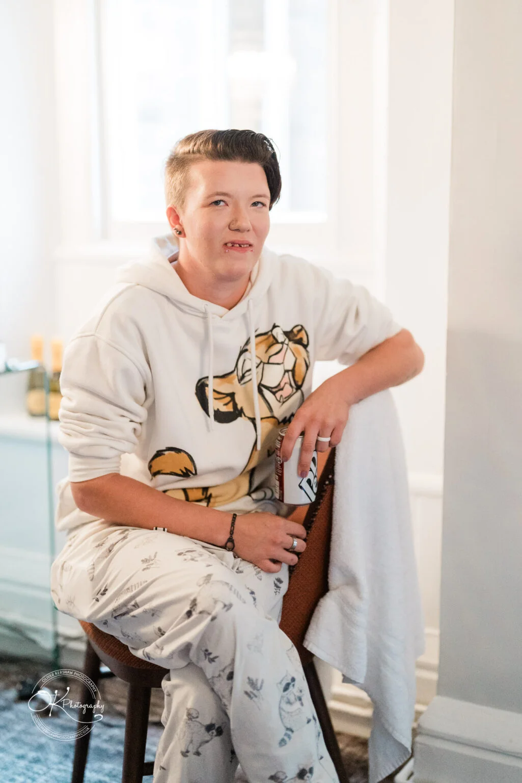 Makeney Hall Hotel - Wedding Photography Person in pyjamas sitting on a chair, holding a can of Pepsi Max.