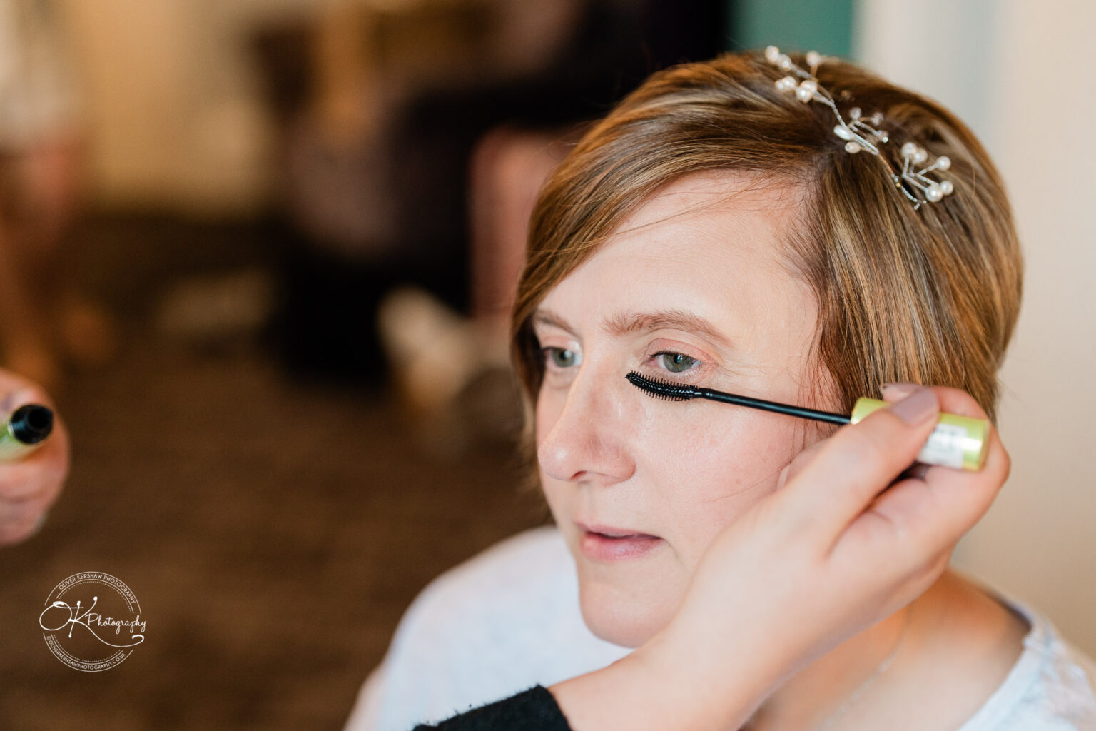 A woman having mascara applied to her eyelashes.