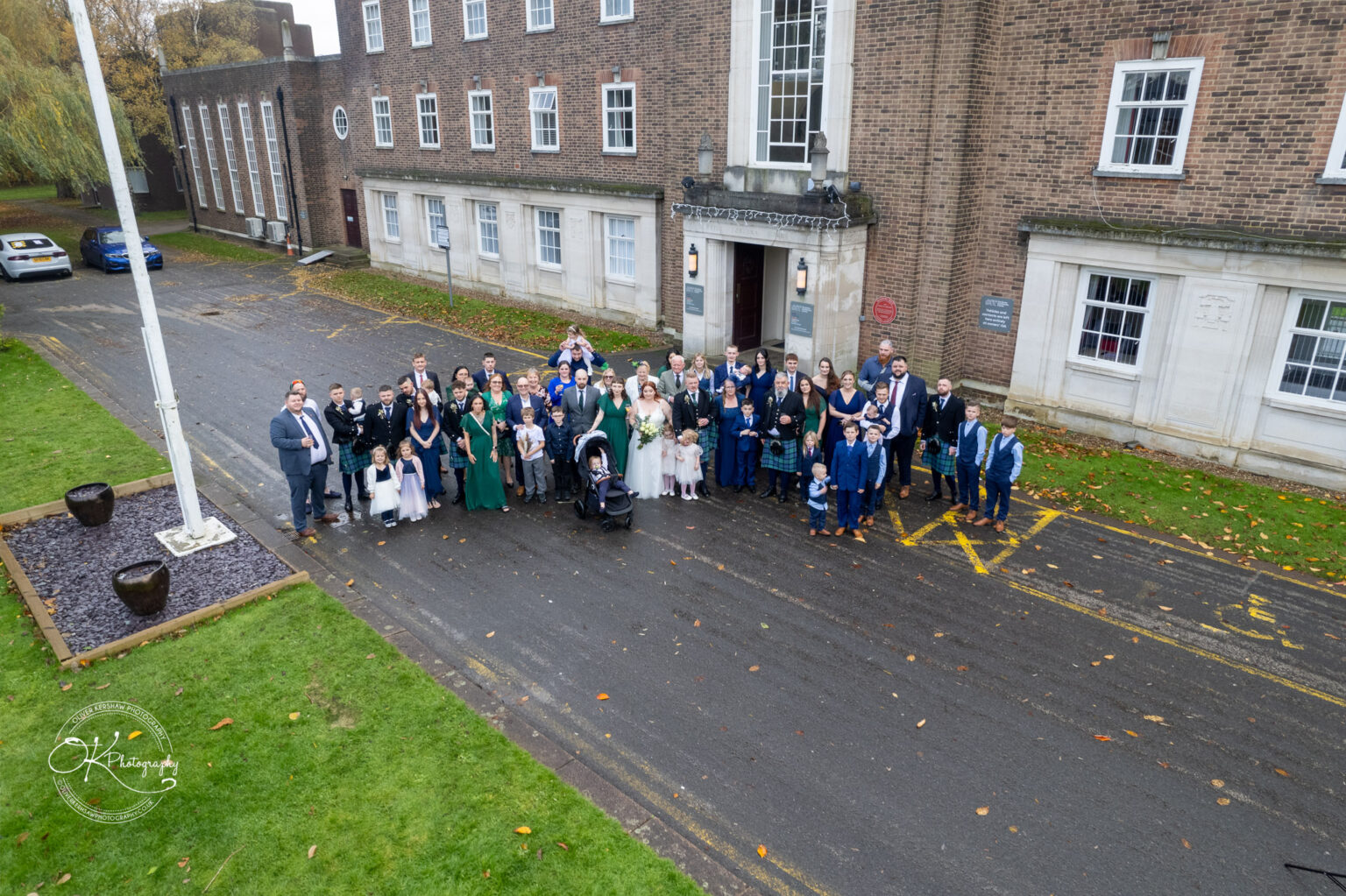 A large group of people posing for a photo outside a brick building identified as the Derby Conference Centre.