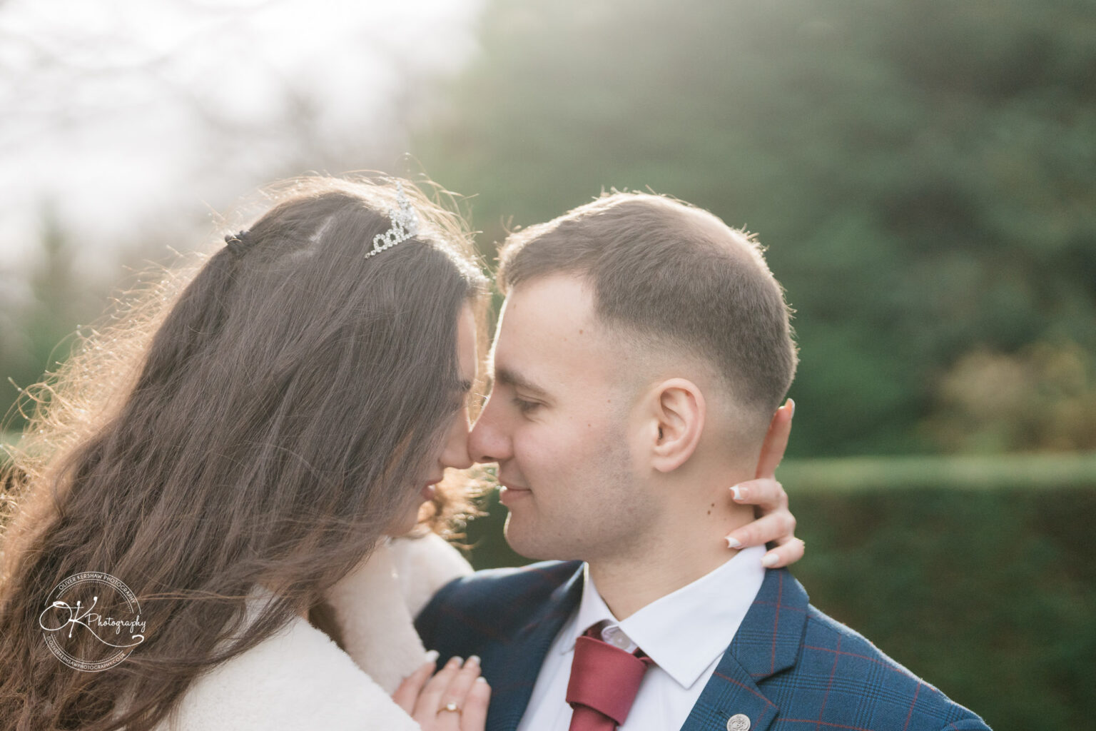 A couple gazing into each other's eyes with foreheads touching.