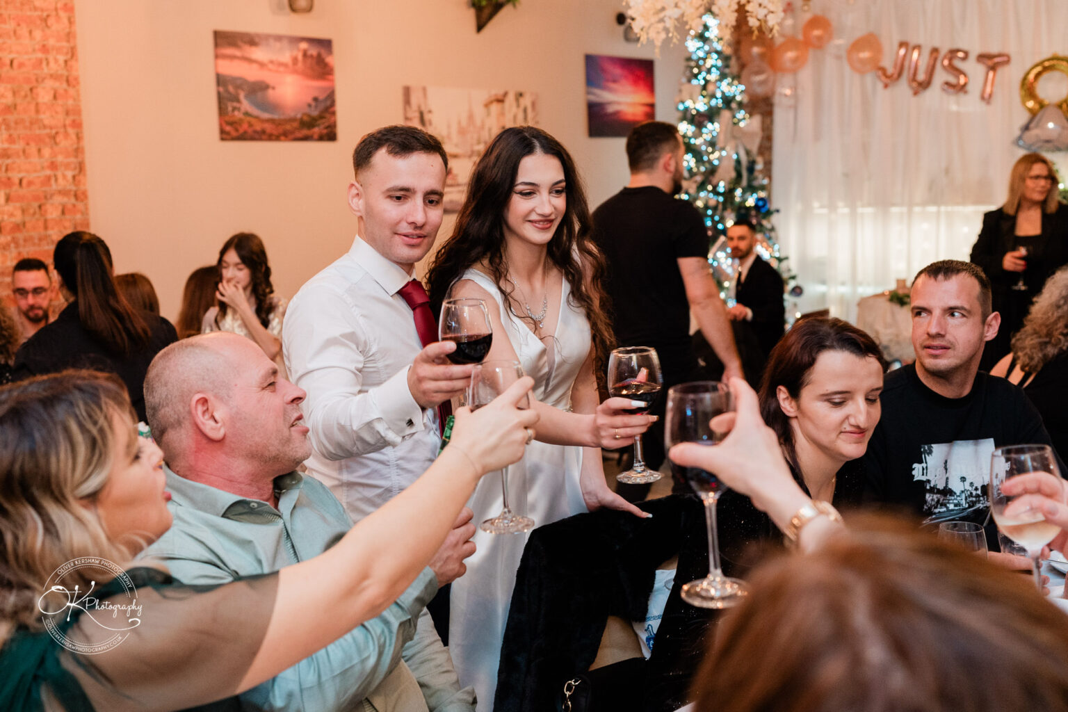 Group of people toasting with wine glasses at a celebration.