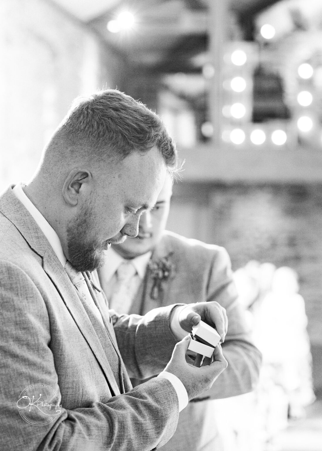 Groom holding wedding ring box at Dodford Manor wedding