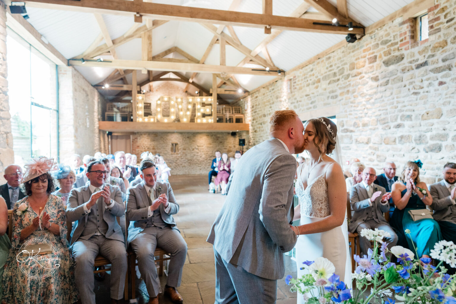 Bride and groom sharing first kiss at Dodford Manor wedding