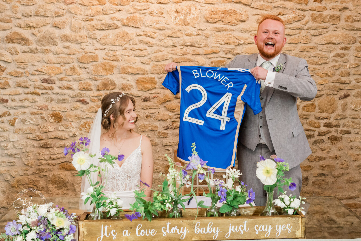 Groom holding personalized jersey at Dodford Manor wedding
