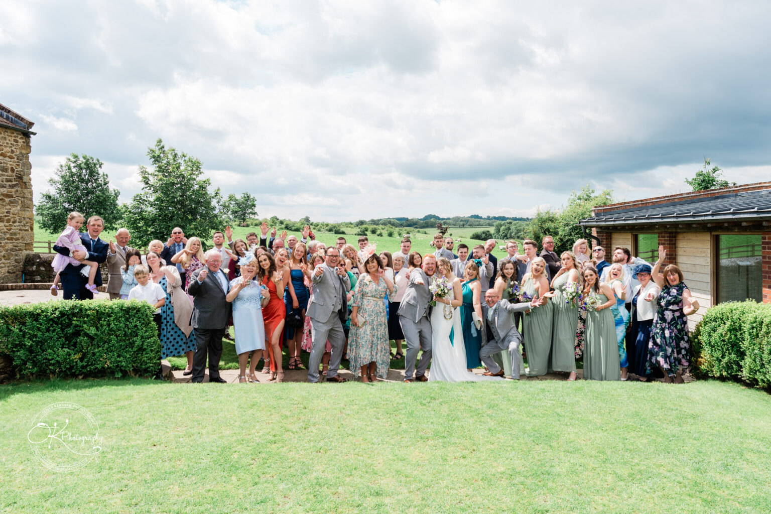 Wedding guests group photo with the bride and groom at Dodford Manor