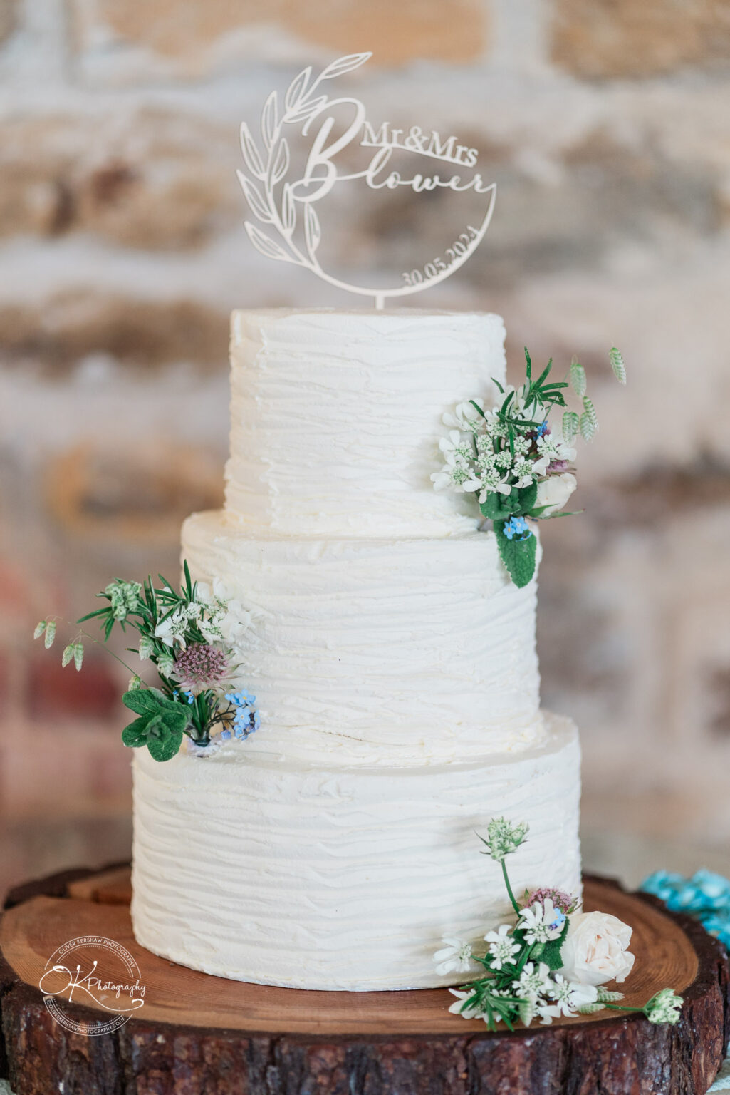 Elegant white wedding cake with floral decorations at Dodford Manor